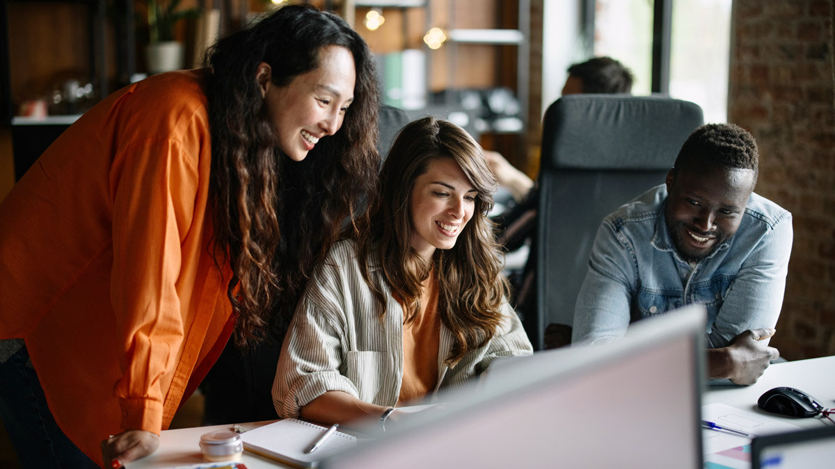 three-coworkers-huddled-around-computer